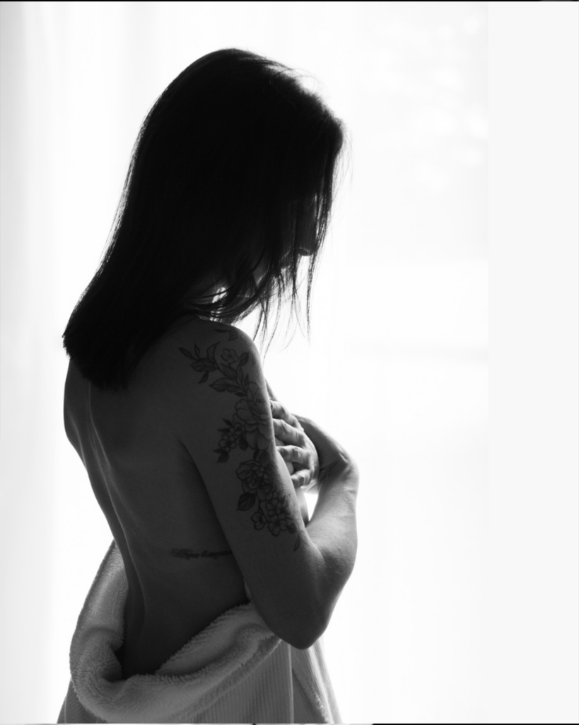 Photo boudoir intimiste en clair-obscur mettant en valeur le corps avec délicatesse