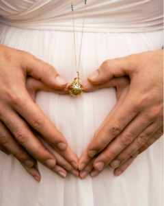 Femme enceinte posant en douceur avec les mains sur son ventre et celle du conjoint